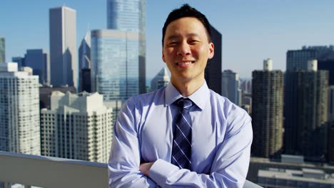 portrait of asian businessman on rooftop overlooking chicago