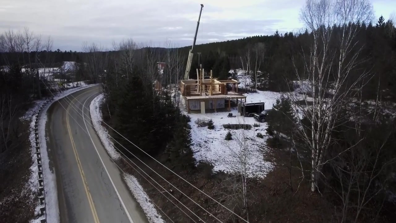 Ripresa con drone di una baita in legno in costruzione. Cantiere in Canada.