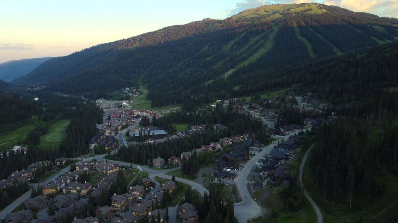 un dron volando sobre la ciudad y las montañas de la estación de esquí de kamloops en canadá.