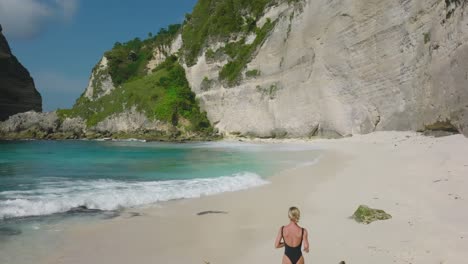 Fitte-Blonde-Frau-Im-Schwarzen-Badeanzug,-Die-In-Zeitlupe-Am-Tropischen-Weißen-Strand-Läuft