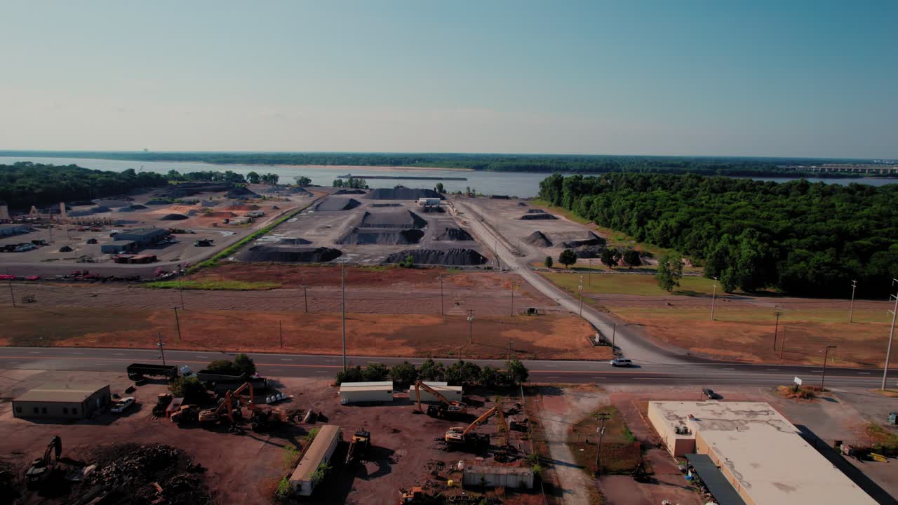 Drone shot showing huge stockpiles of construction materials and heavy equipment next to the Mississippi River in Memphis, TN