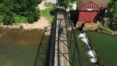 iconic one-lane steel bridge across calm stream, rural arkansas