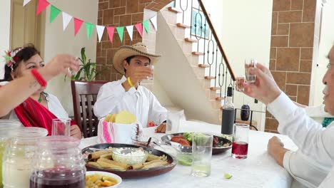 Happy-Mexican-family-laughing-at-joke-during-lunch