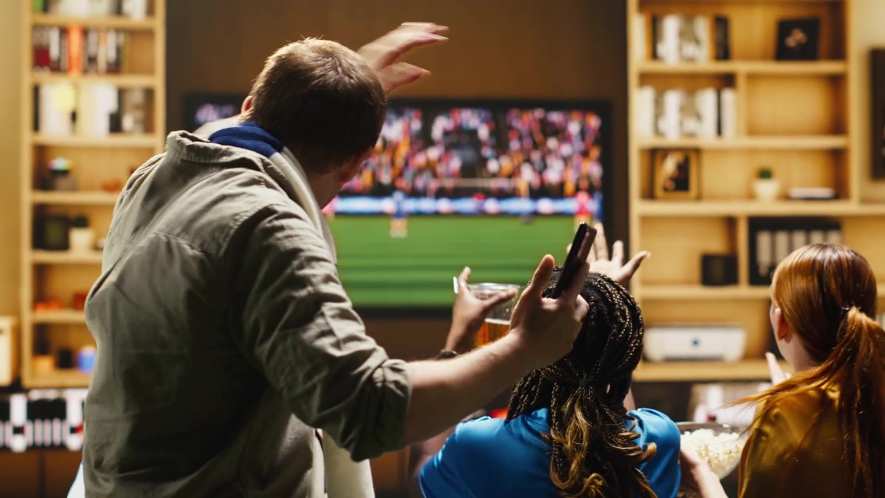 Close up of upset football supporter at home on couch holding smartphone