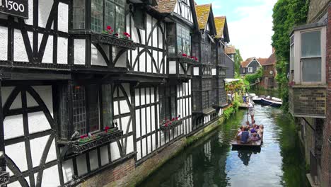 boats are rowed down a canal surrounded by beautiful architecture in canterbury kent england