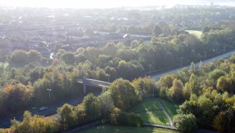 aerial view looking down above countryside dual carriageway country road between woodland treetop at sunrise