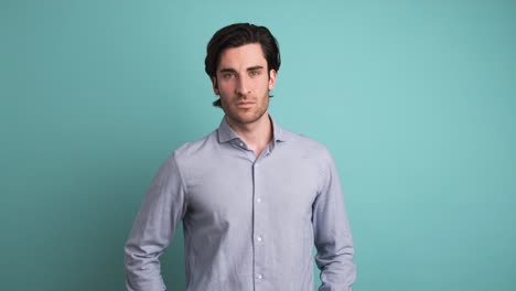 serious man looking at camera in blue studio