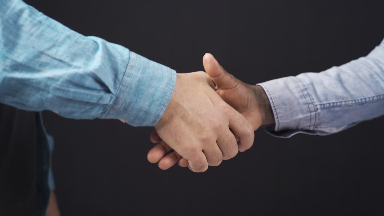 Primo piano di una stretta di mano tra un uomo africano e un uomo bianco. Accordo, saluto, incontro