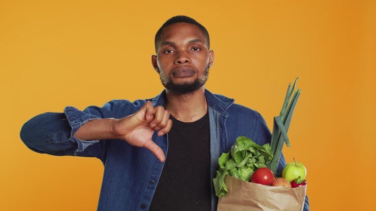 Young adult showing a thumbs down symbol in studio