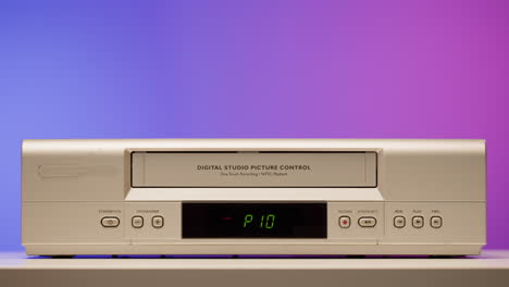 vintage vhs player with hand inserting tape