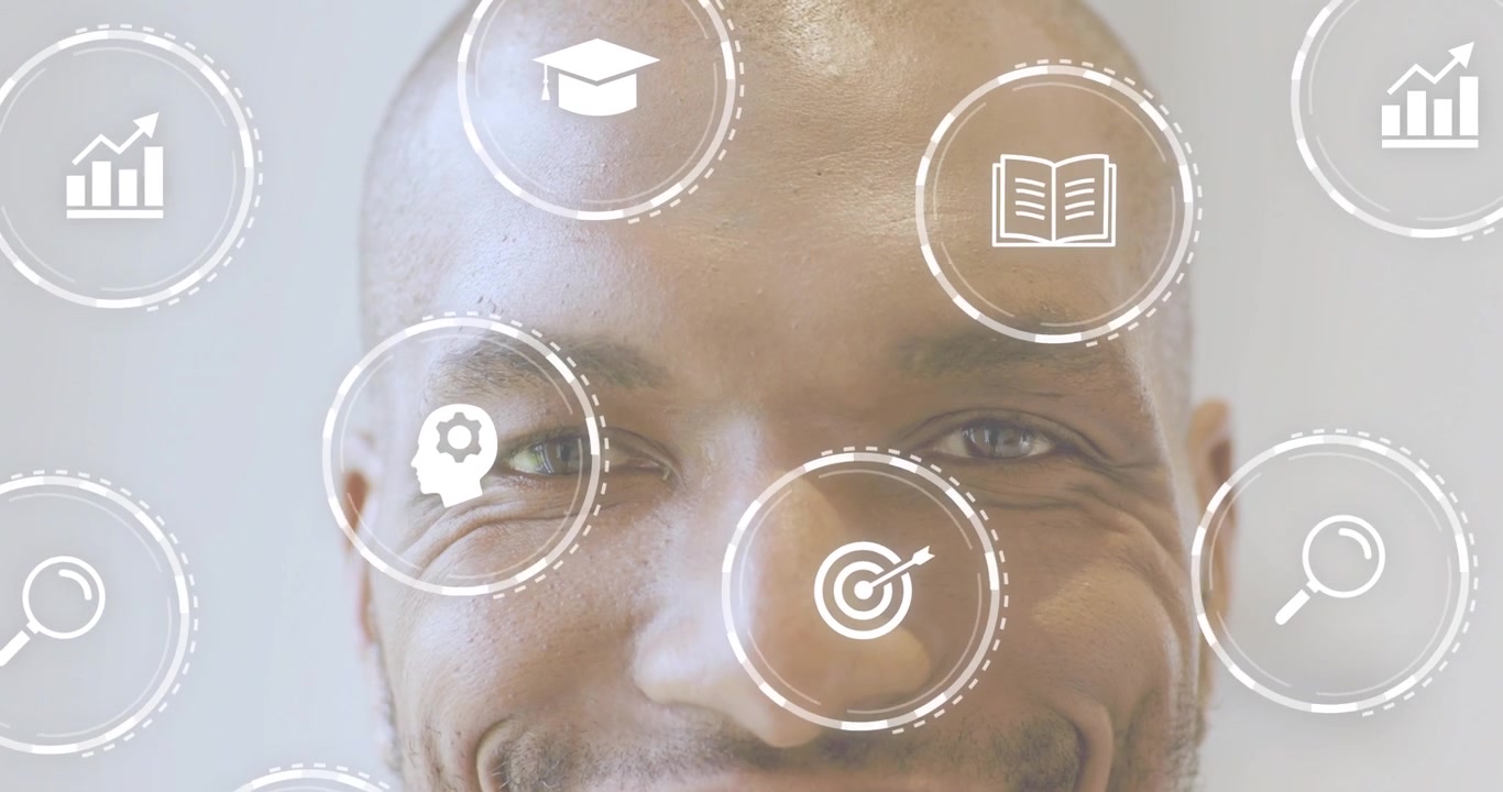 Man holding gaze upon learning icons forming ring around head book chart fading then smiling