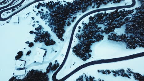 Aerial,-a-serpentine-road-in-snowy-Alps-mountains-in-Austria