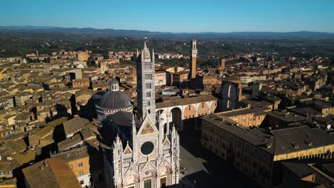 una toma aérea revela la plaza campo y la torre mangia en siena, italia