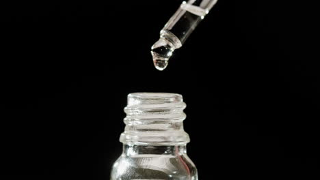 dropper filling a small glass bottle