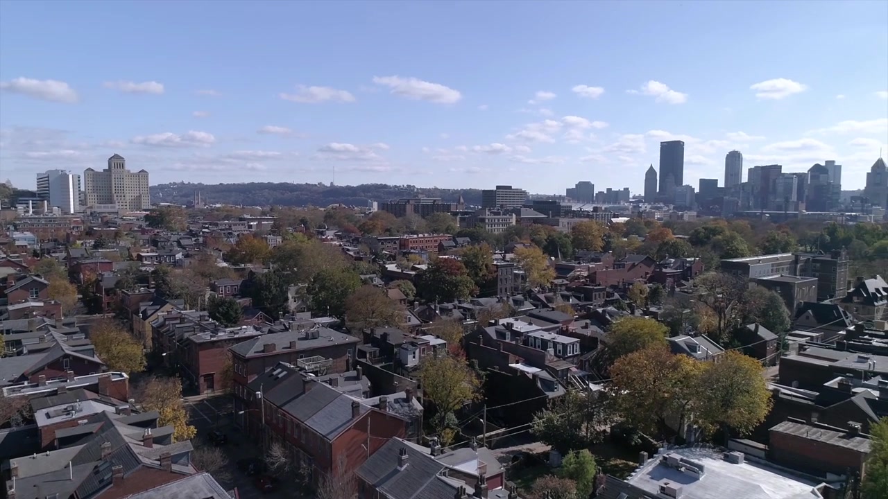 A daytime twisting, tilt-up aerial establishing shot of Pittsburgh's Manchester neighborhood.
