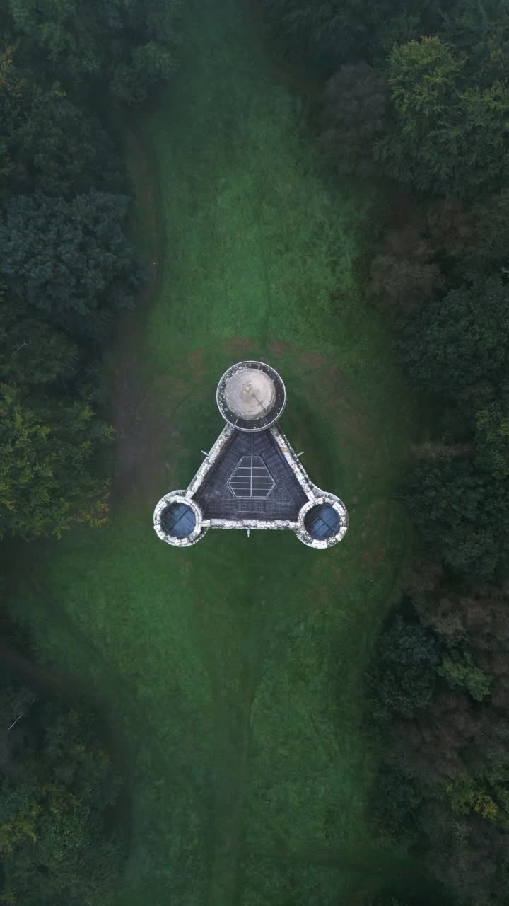 Vertical drone shot above the King Alfred Castle, dark, misty day in England