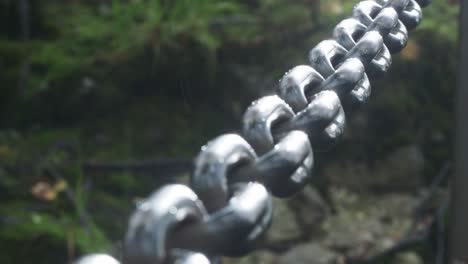 pan across chain barrier with sun rays shinning on metal links