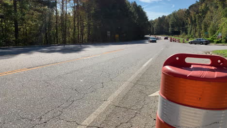 clip of a road under construction with traffic cones and passing vehicles