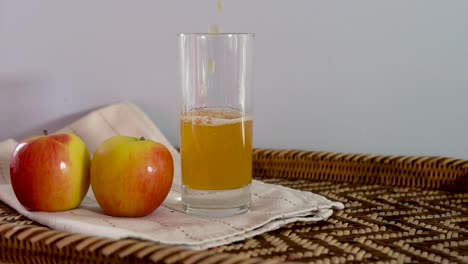 vinagre de sidra orgánico fresco vertido en vaso en bandeja con manzanas