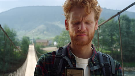 sad traveler reading mobile phone screen. hitchhiker looking map in mountains.