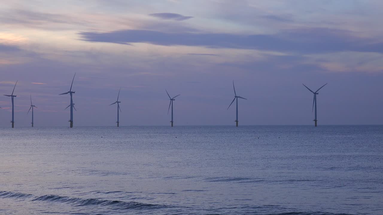 풍력 발전소는 일몰 1에서 해안선을 따라 전기를 생성합니다.