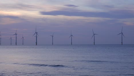 a wind farm generates electricity along a coastline at sunset 1