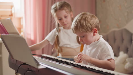 diligent boy plays simple childish melody on digital piano