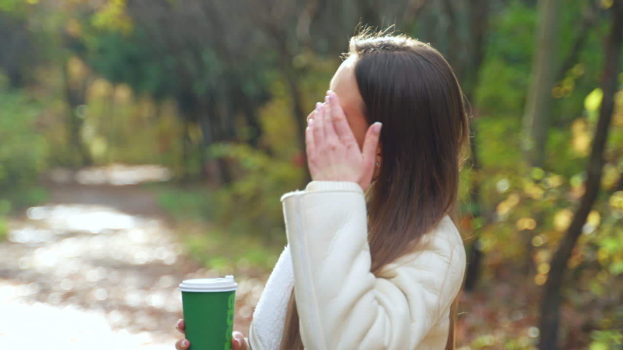 Woman enjoying coffee in the park in autumn