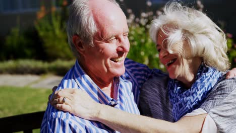 vista frontal de una pareja de ancianos caucásicos activos abrazándose en el jardín de un asilo de ancianos 4k