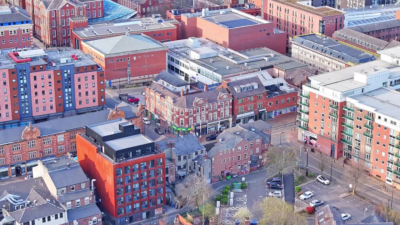 Aerial drone tilts up in Sheffield United Kingdom traditional city buildings and streets, UK cityscape