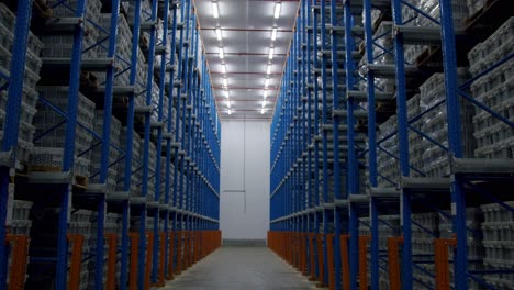 pov of a person walking in narrow aisle of warehouse with pallet racking system