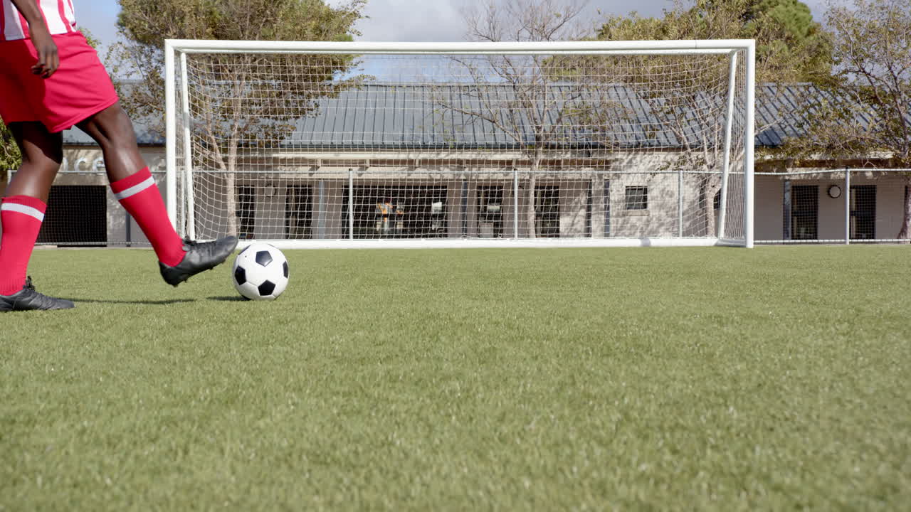 Soccer ball on grass field in front of goalpost, ready for kick-off, copy space