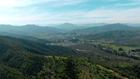 Flyover-scenic-mountain-landscape-in-central-chile,-vineyards-sprawling-in-the-valley,-Chile