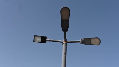 4k: farola led en el poste de metal alto bajo el cielo azul claro, poste de luz de calle led eléctrico moderno, tiro de ángulo bajo-1