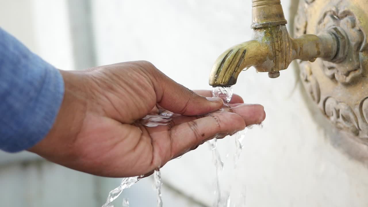 persona lavando las manos con agua de un grifo