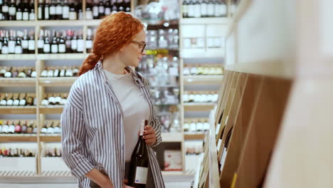 kaukasische junge frau wählt eine flasche wein in einem supermarkt