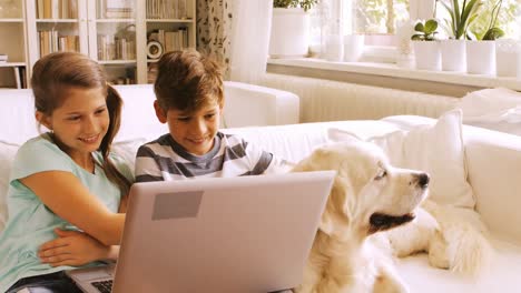 Niños-Usando-Una-Computadora-Portátil-En-El-Sofá-De-La-Sala-De-Estar