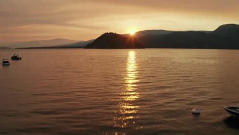 Aerial-Flyby-Over-Canadian-Dock-and-Lake-with-Boats-During-Beautiful-Evening-Sunset