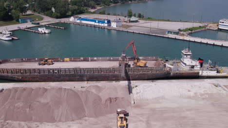 bird's eye view of loader crane offloading gravel from sam laud container ship at kingsville harbour