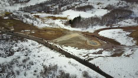 vista aérea de los visitantes en el área de aguas termales de geysir en islandia.