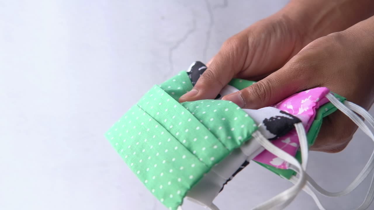 máscaras de tela coloridas en las manos