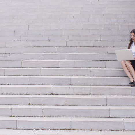 Business-woman-with-laptop-on-stairs