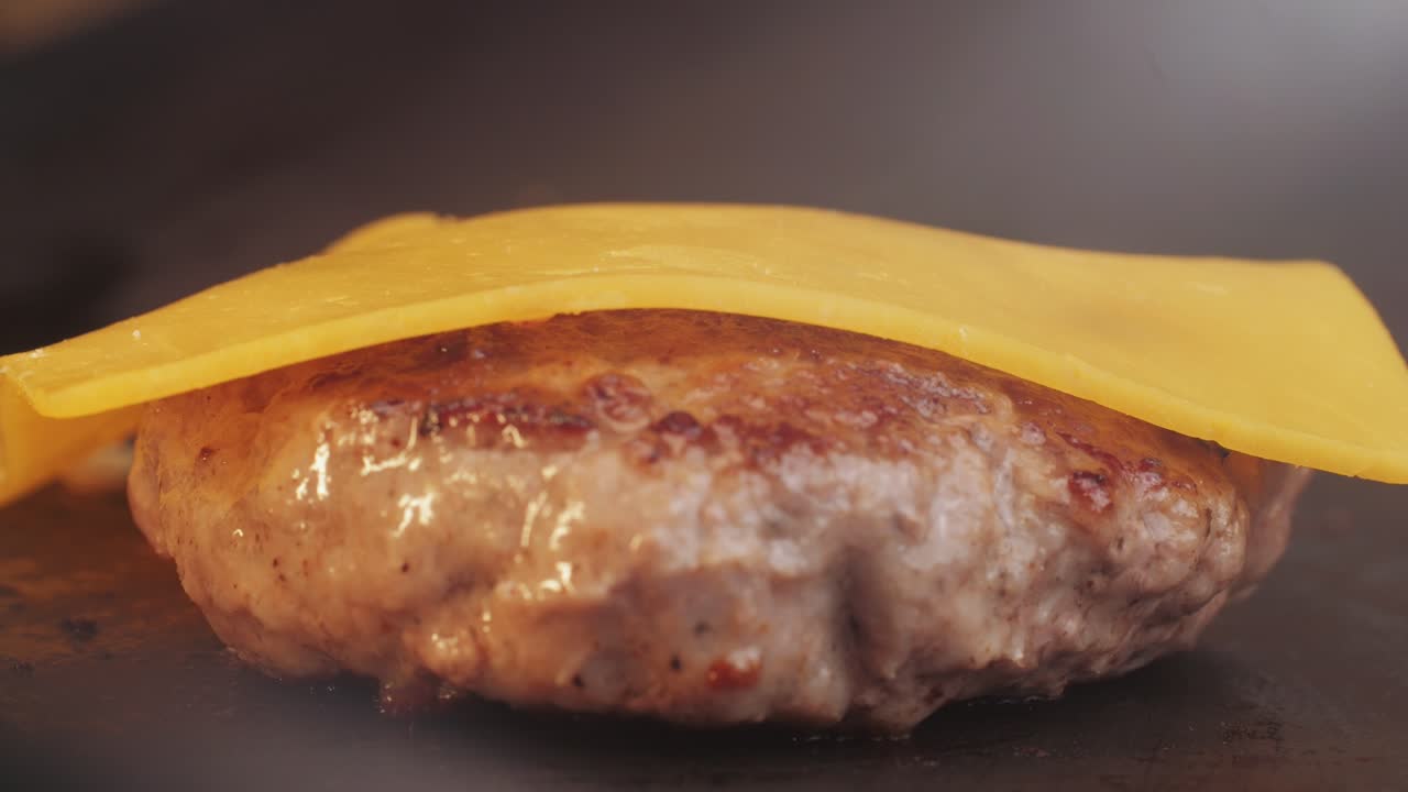 Cooking American fat smash burger on grill close-up. Beef or pork cutlet smashing by burger press. The chef in kitchen of the restaurant making cutlets for burgers - smash burger beefsteak. Fast and street food concept. High quality 4k footage