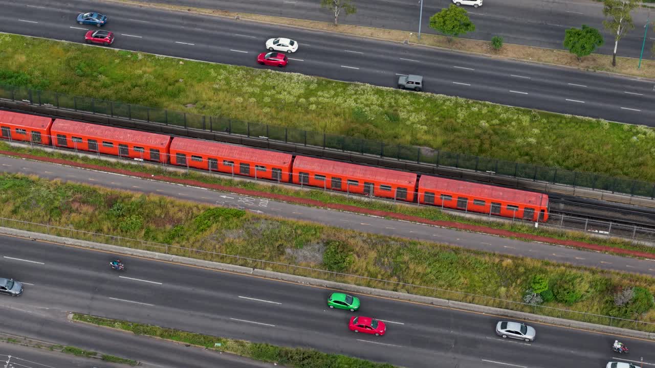 Drone footage of orange Mexico City Metro train on Ecatepec Avenue