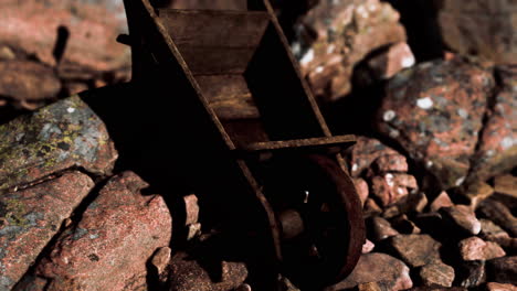 abandoned wooden mine wheelbarrow on rocks