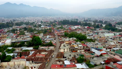 Descending-drone-shot-of-San-Cristobal-de-las-Casas-Mexico,-streets-and-buildings