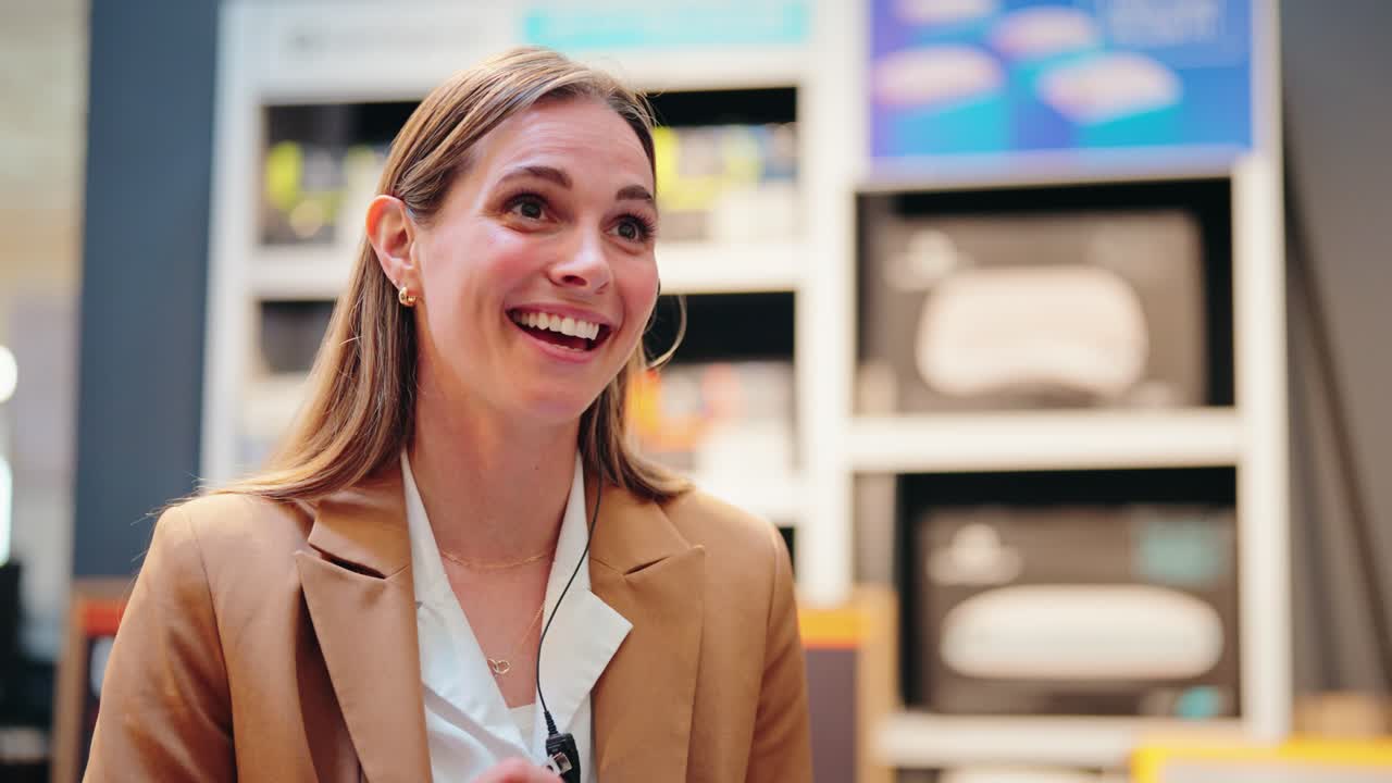 Blonde associate talks happily while backlit before pillow wall slow motion