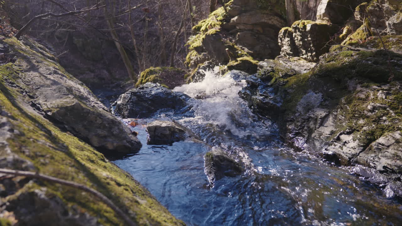 River splashes into the rocks and flows further in slow motion