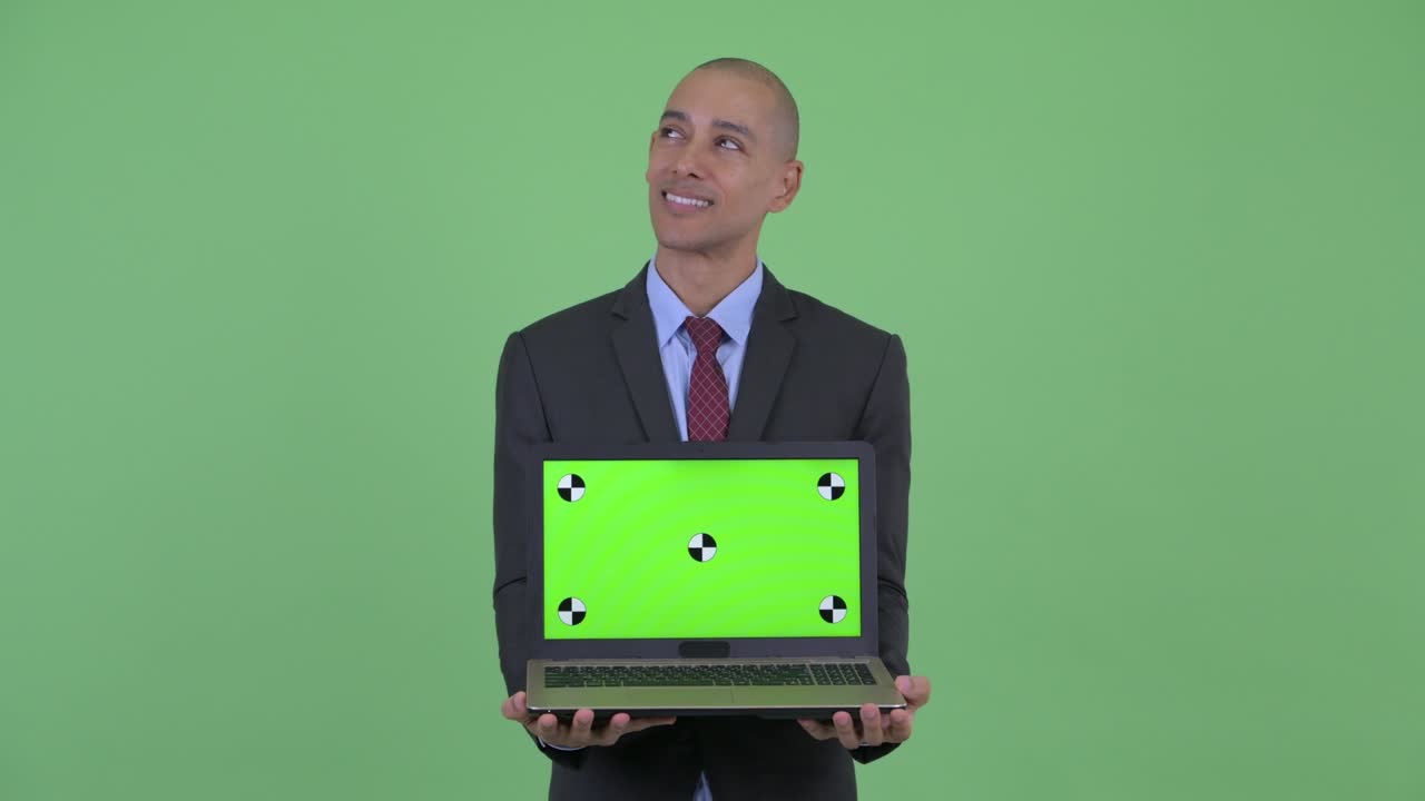 feliz guapo calvo multiétnico hombre de negocios mostrando portátil