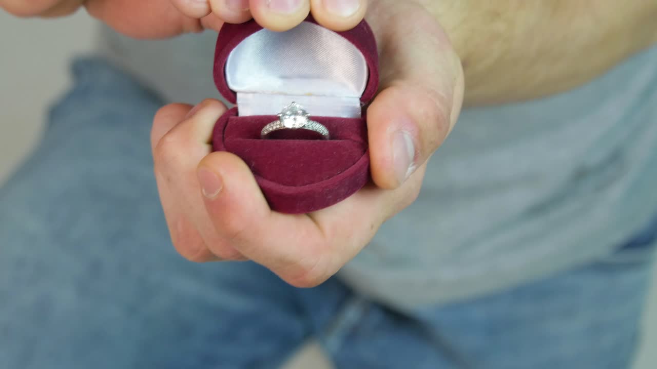 Man Holding Engagement Ring in a Red Box